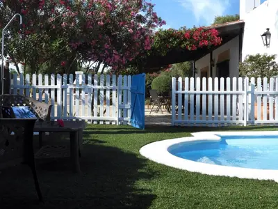 a white picket fence next to a swimming pool at Vivienda Rural Los Madroños in Malcocinado