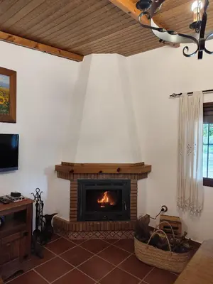 a living room with a fireplace in the wall at Vivienda Rural Los Madroños in Malcocinado