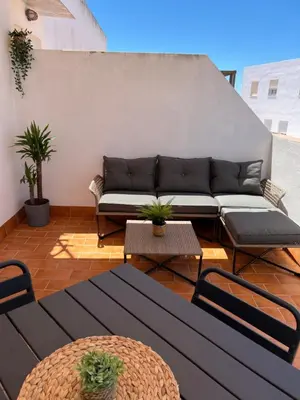 a living room with a couch and tables at Ático con terraza - 2 minutos de la playa in Rota