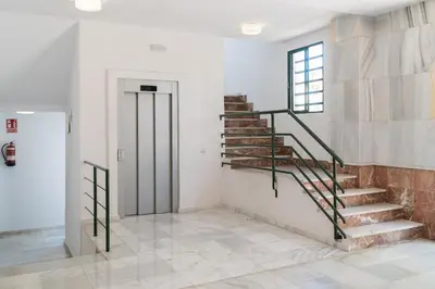 a staircase in a white room with a window at Ancora - Piscina & Playa in El Puerto de Santa María