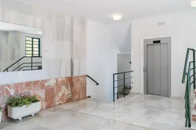 a hallway with white walls and a staircase and a door at Ancora - Piscina & Playa in El Puerto de Santa María