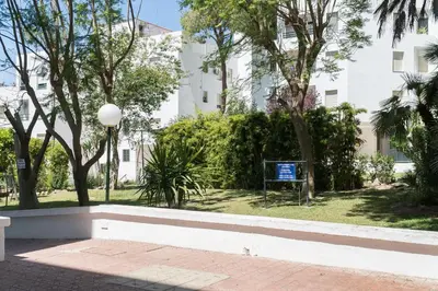 a park in front of a white building at Ancora - Piscina & Playa in El Puerto de Santa María