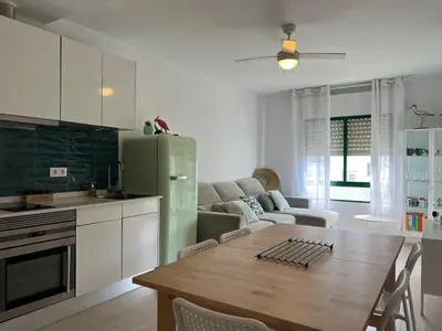 a kitchen and living room with a table and a green refrigerator at Ancora - Piscina & Playa in El Puerto de Santa María