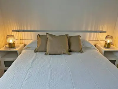 a white bed with two lamps on both sides of it at Apartamento El Tabanco - Ole Solutions in Jerez de la Frontera