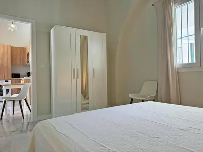 a bedroom with a bed and a table and chairs at Apartamento El Tabanco - Ole Solutions in Jerez de la Frontera