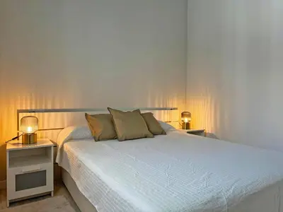 a bedroom with a white bed with two night stands at Apartamento El Tabanco - Ole Solutions in Jerez de la Frontera