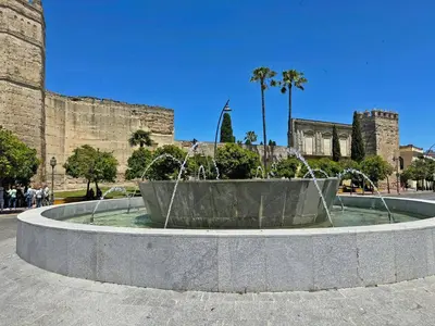 a fountain in front of a castle with people standing around it at Apartamento El Tabanco - Ole Solutions in Jerez de la Frontera