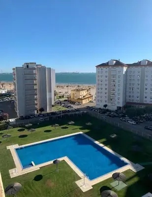 a large swimming pool in a city with buildings at Espectacular Valdemar in El Puerto de Santa María