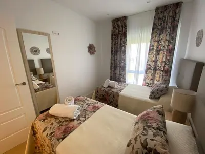 a hotel room with two beds and a mirror at Espectacular Valdemar in El Puerto de Santa María
