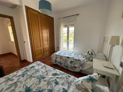 a room with two beds and a table and a window at Villa Loma Cris y Javi in Cádiz