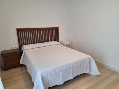 a bedroom with a white bed and a wooden dresser at Cabildo Plaza 1 Sanlúcar de Barrameda in Sanlúcar de Barrameda