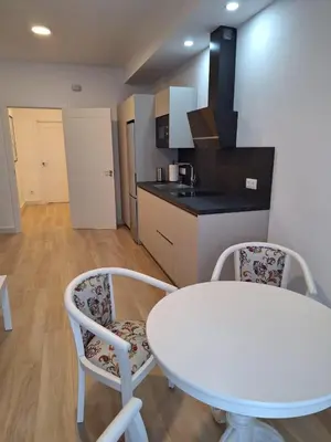 a white table and two chairs in a kitchen at Cabildo Plaza 1 Sanlúcar de Barrameda in Sanlúcar de Barrameda