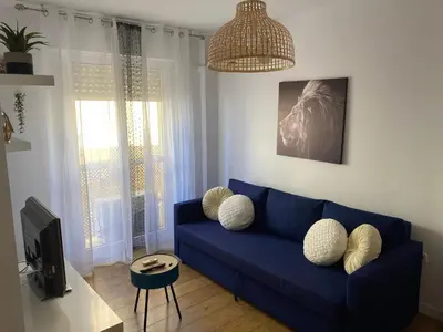a living room with a blue couch and a tv at Apartamento La Isla in San Fernando