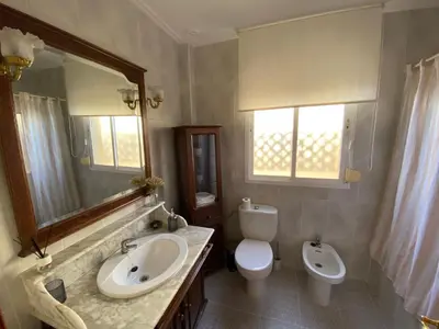a bathroom with a sink and a toilet and a mirror at Apartamento La Isla in San Fernando