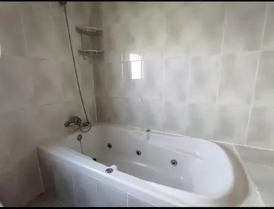a white bath tub in a white tiled bathroom at Apartamento La Isla in San Fernando