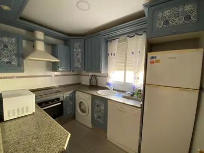 a kitchen with blue cabinets and a white refrigerator at Apartamento La Isla in San Fernando