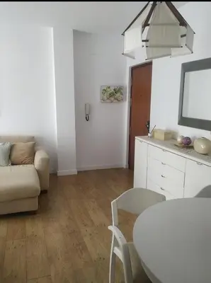 a white living room with a table and a couch at Apartamento La Isla in San Fernando
