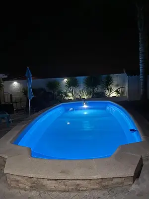 a large blue swimming pool at night at Acogedora casa de invitados con piscina 1 in El Puerto de Santa María