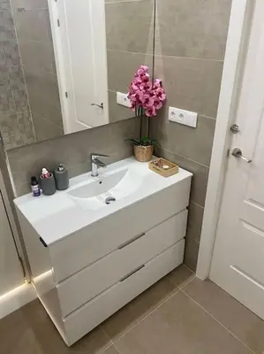 a bathroom with a sink with a vase of flowers on it at Acogedora casa de invitados con piscina 1 in El Puerto de Santa María