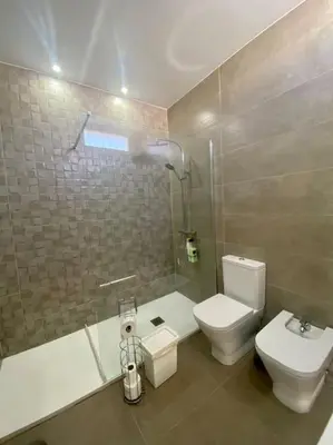 a bathroom with a toilet and a sink and a shower at Acogedora casa de invitados con piscina 1 in El Puerto de Santa María