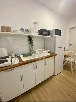 a kitchen with white cabinets and a white refrigerator at Acogedora casa de invitados con piscina 1 in El Puerto de Santa María