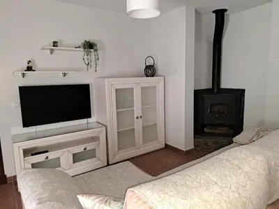 a living room with a television and a fireplace at La Cuesta in Medina Sidonia