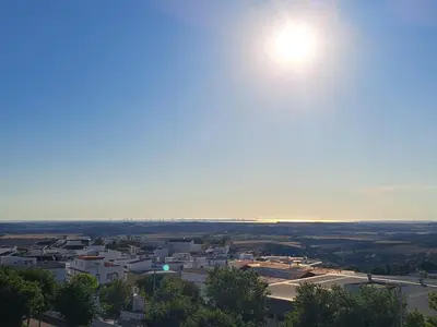 a view of a city with the sun in the sky at La Cuesta in Medina Sidonia