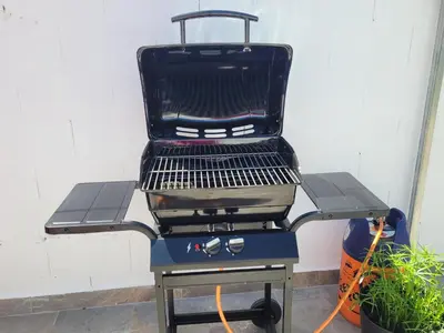 a barbecue grill sitting next to a white wall at Casa Felicidad in Chiclana de la Frontera