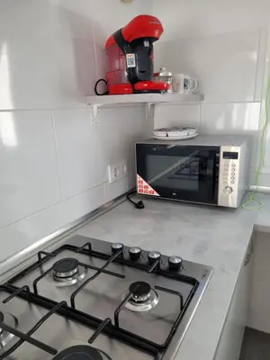 a kitchen with a stove and a microwave at Casa Felicidad in Chiclana de la Frontera