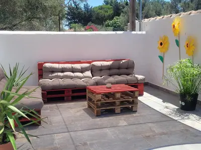 a couch sitting on a patio with a table at Casa Felicidad in Chiclana de la Frontera