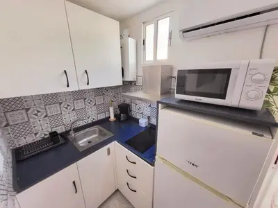 a small kitchen with a microwave and a sink at Brisa del Mar in Chiclana de la Frontera