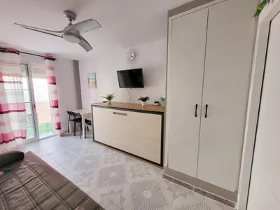 a living room with a large white cabinet and a table at Brisa del Mar in Chiclana de la Frontera