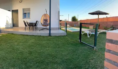 a patio with a table and chairs and an umbrella at Ohana in Conil de la Frontera