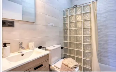 a bathroom with a toilet and a sink and a shower at Ohana in Conil de la Frontera