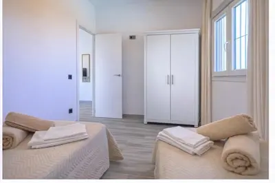 a white room with two beds and a large window at Ohana in Conil de la Frontera