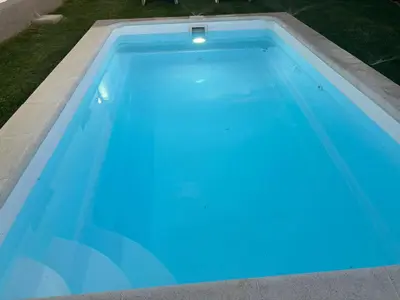 a swimming pool with blue water in a yard at Ohana in Conil de la Frontera