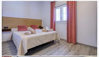 a bedroom with a bed and a large window at Ohana in Conil de la Frontera
