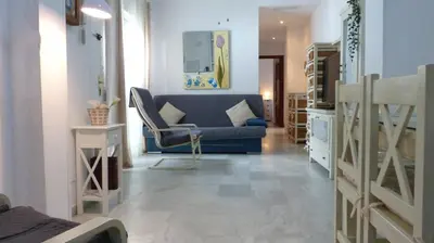 a living room with a blue couch and a chair at fantástico apartamento chipiona in Chipiona
