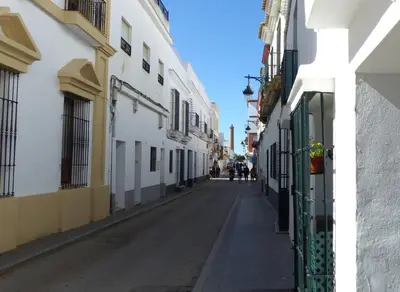 an empty street in a city with white buildings at fantástico apartamento chipiona in Chipiona