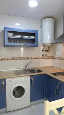 a kitchen with a sink and a washing machine at fantástico apartamento chipiona in Chipiona