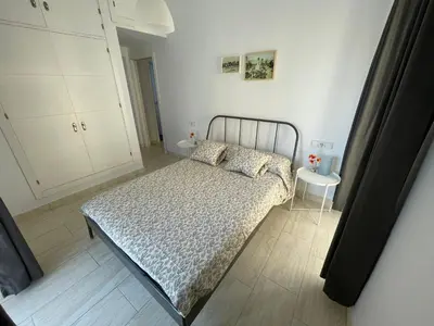 a small bedroom with a bed and a table at Apartamento en pleno centro de Jerez de la Frontera in Jerez de la Frontera