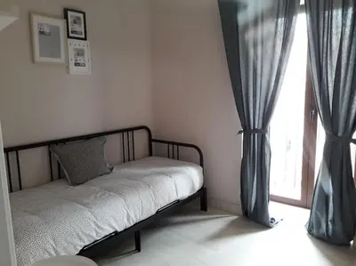 a bed sitting in a room with a window at Apartamento en pleno centro de Jerez de la Frontera in Jerez de la Frontera
