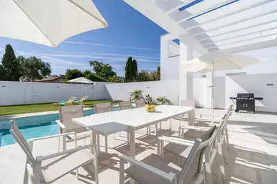 a white dining room with a white table and chairs at Elena Sea Villa in Poblado de Sancti Petri