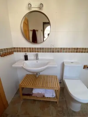 a bathroom with a sink and a toilet and a mirror at Casa Playa la Jara in Sanlúcar de Barrameda