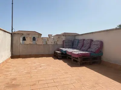 a row of cushioned benches sitting on a patio at Casa Playa la Jara in Sanlúcar de Barrameda