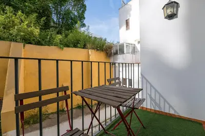 a wooden table and chair on a balcony at Carmen Viejo in Sanlúcar de Barrameda
