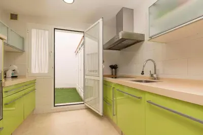 a kitchen with green cabinets and a large window at Carmen Viejo in Sanlúcar de Barrameda