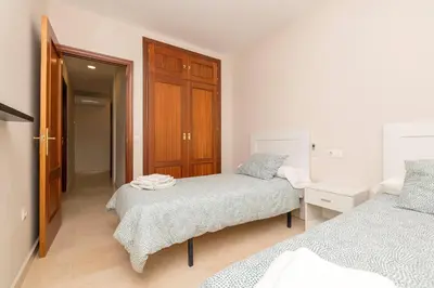 a bedroom with two beds and a wooden cabinet at Carmen Viejo in Sanlúcar de Barrameda