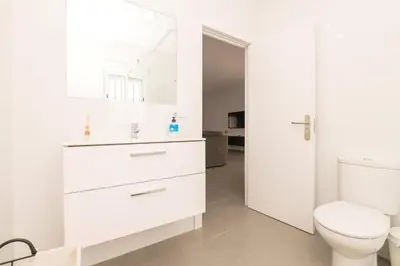 a white bathroom with a toilet and a sink at Miamar 2 in Hozanejos