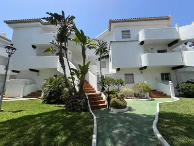 a large white building with palm trees in the yard at La Barrosa in Novo Sancti Petri